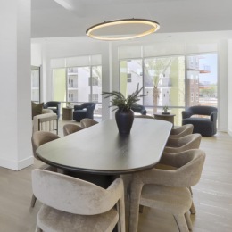 a clubroom with a tv, couches, tables and chairs