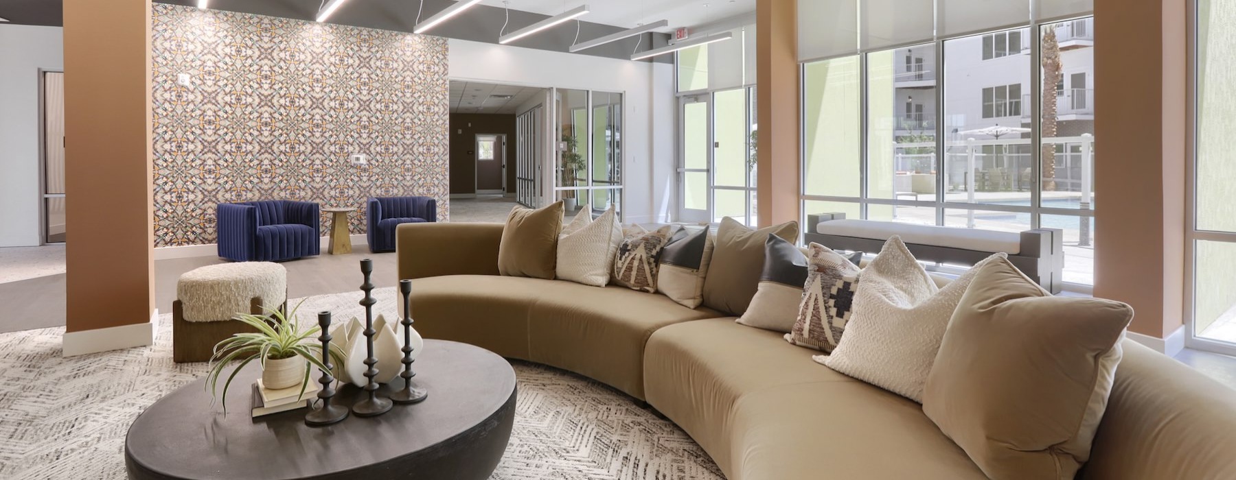 a clubroom with a couch, tables and chairs